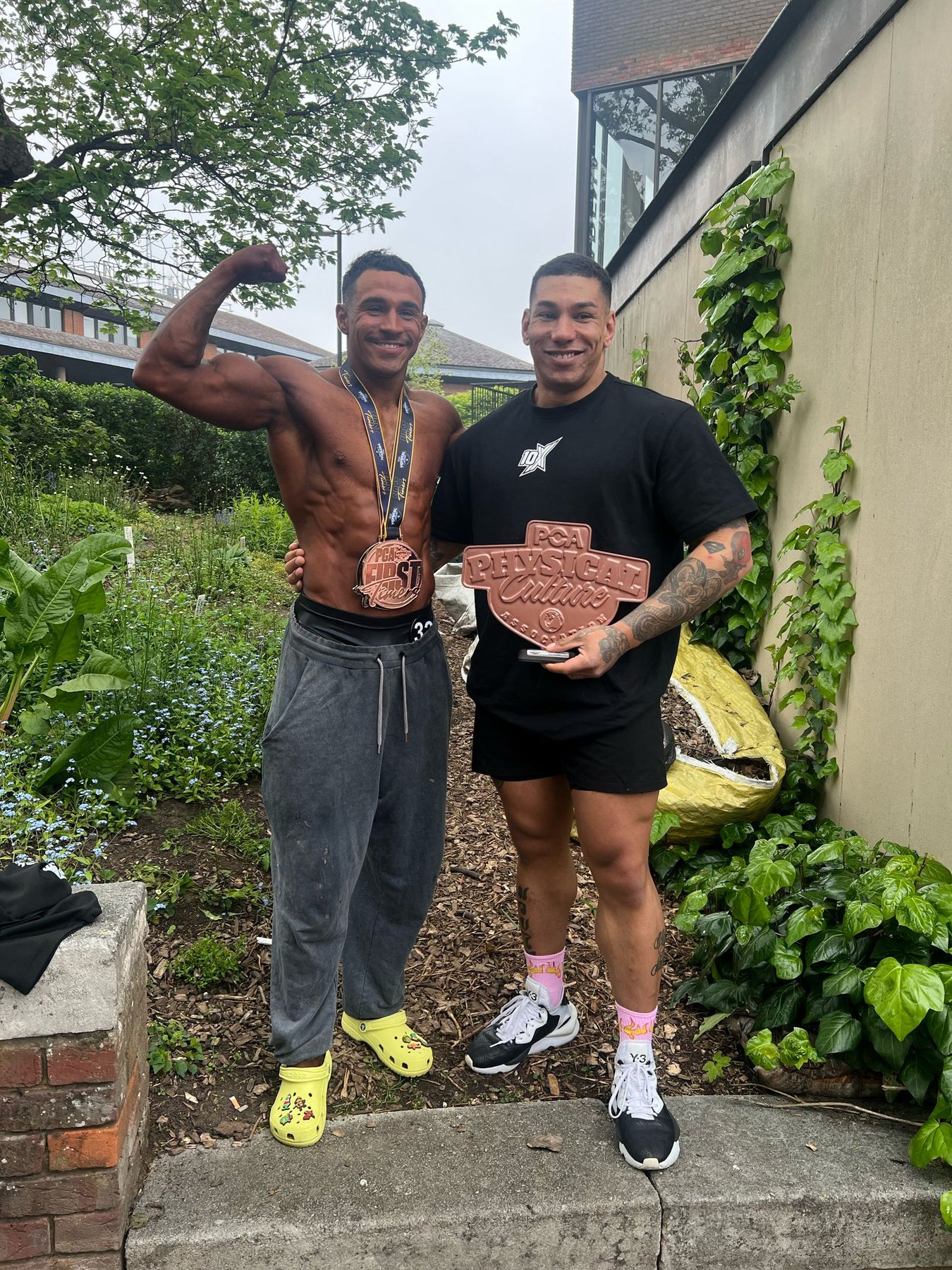 Jonny Goodall with client at bodybuilding competition holding trophy